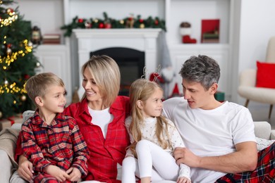 Happy family in pajamas on sofa at home. Christmas morning