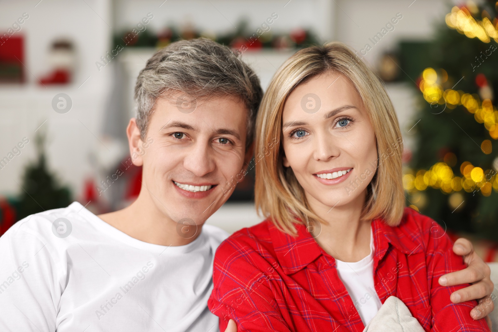 Photo of Portrait of lovely couple at home against blurred Christmas lights