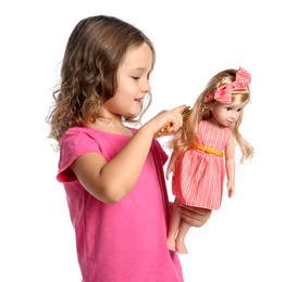 Cute little girl brushing doll's hair on white background