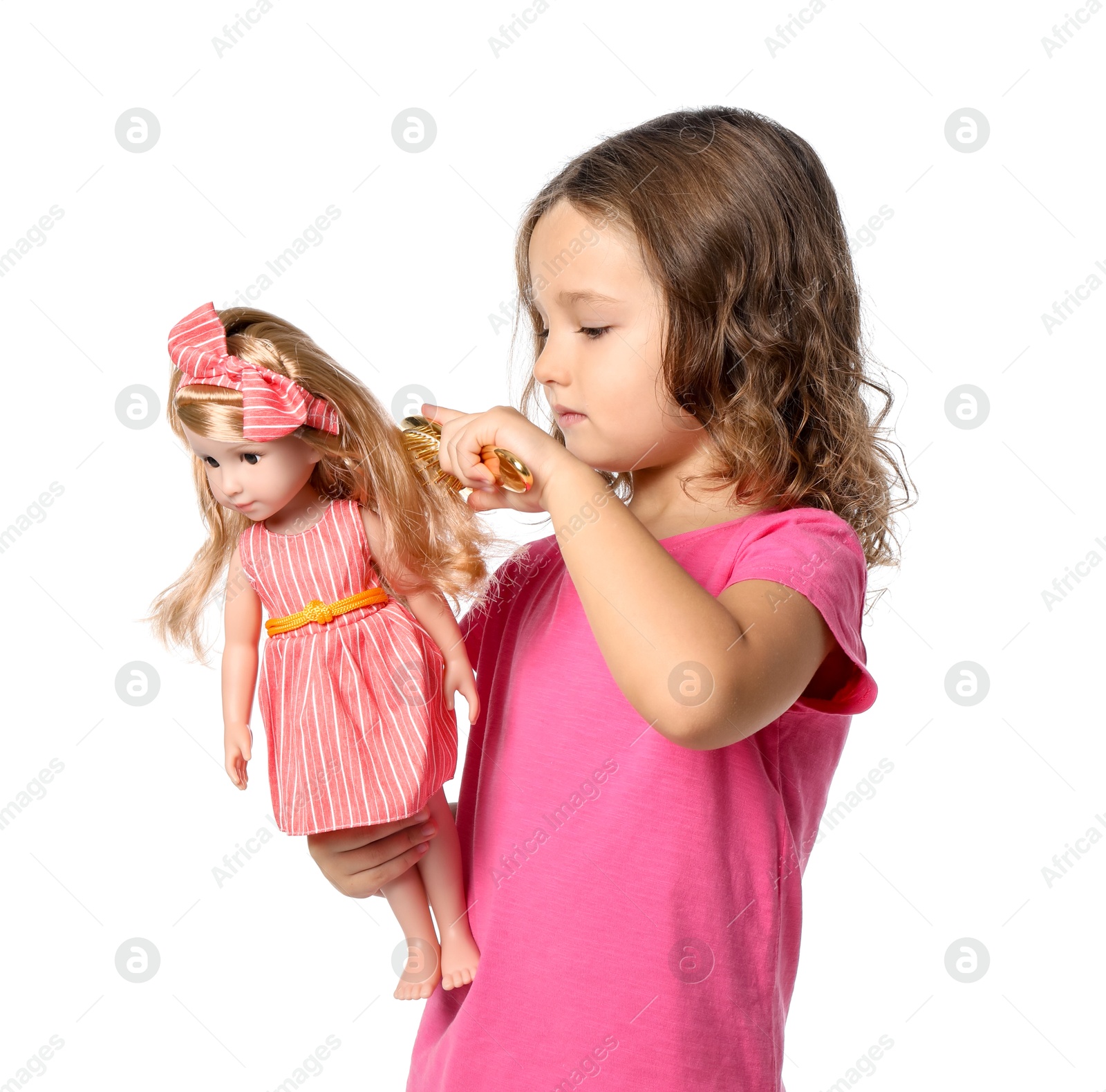 Photo of Cute little girl brushing doll's hair on white background