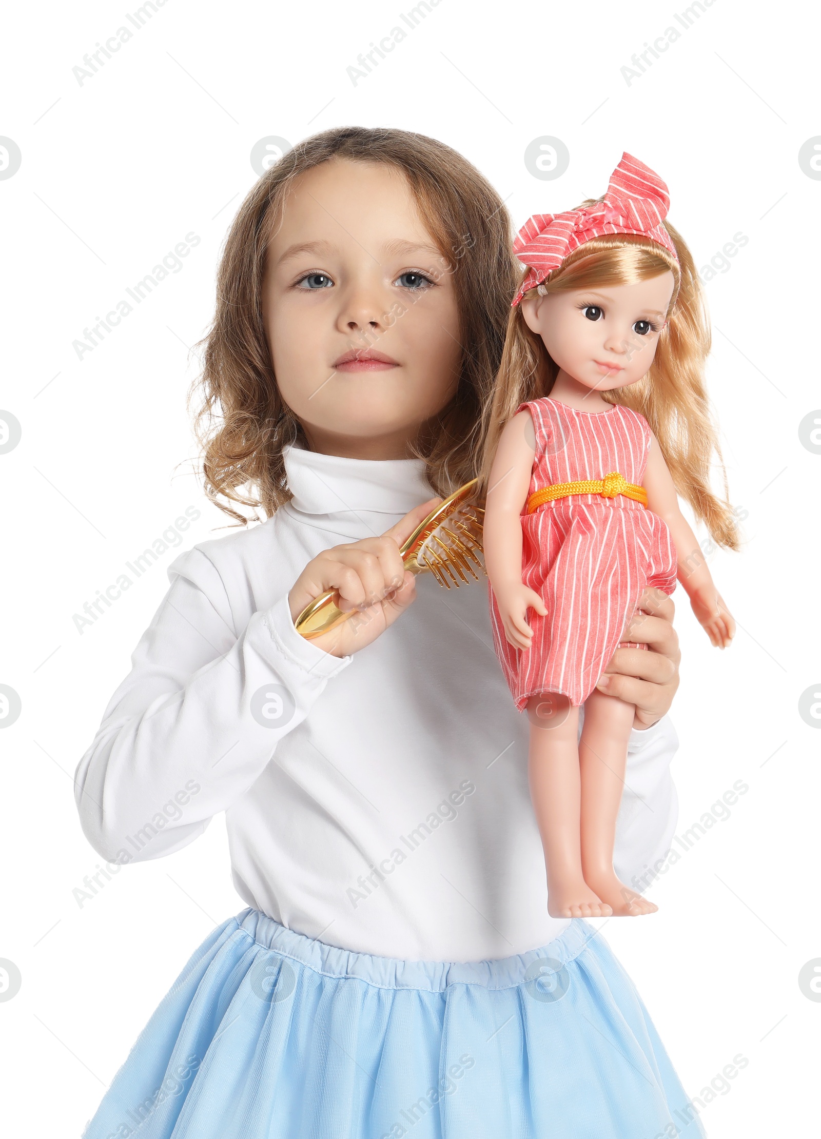 Photo of Cute little girl brushing doll's hair on white background