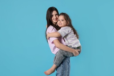 Photo of Portrait of cute sisters on light blue background