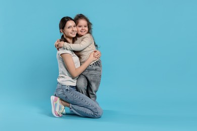 Photo of Portrait of cute sisters on light blue background