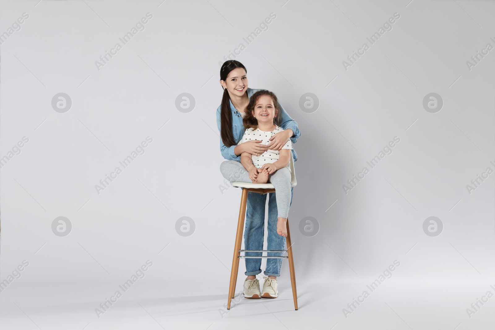 Photo of Portrait of cute sisters on white background