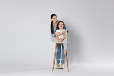 Photo of Portrait of cute sisters on white background