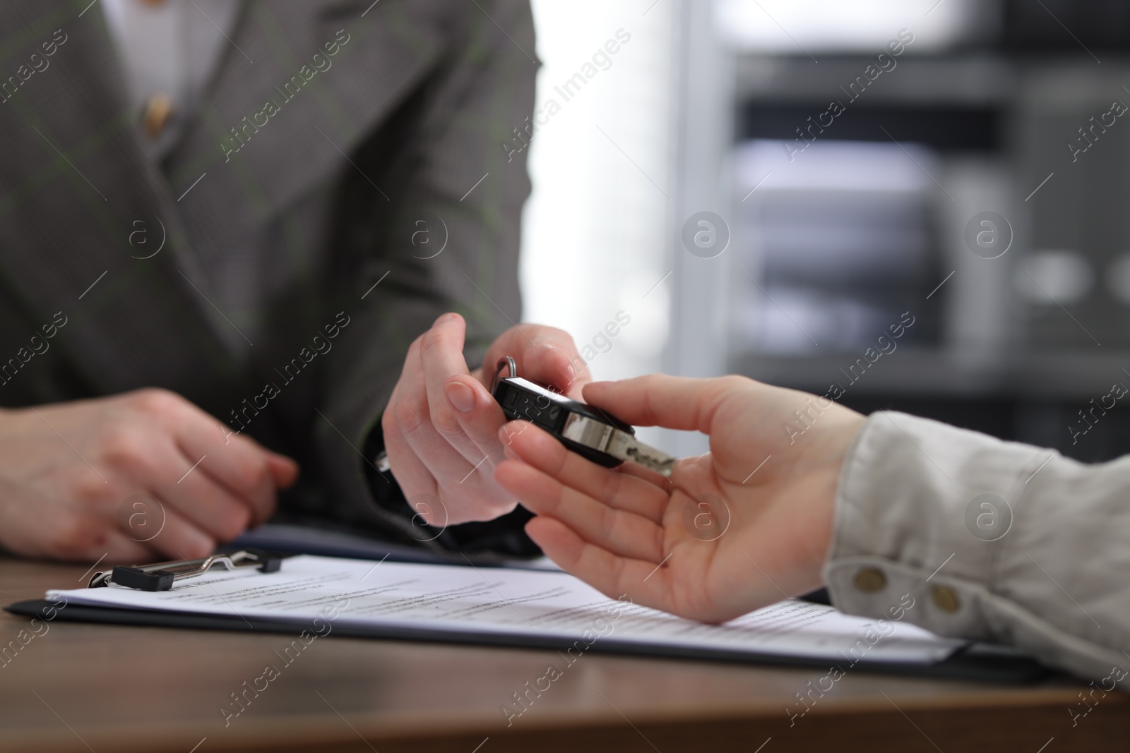 Photo of Buying auto. Client getting car key at table, closeup