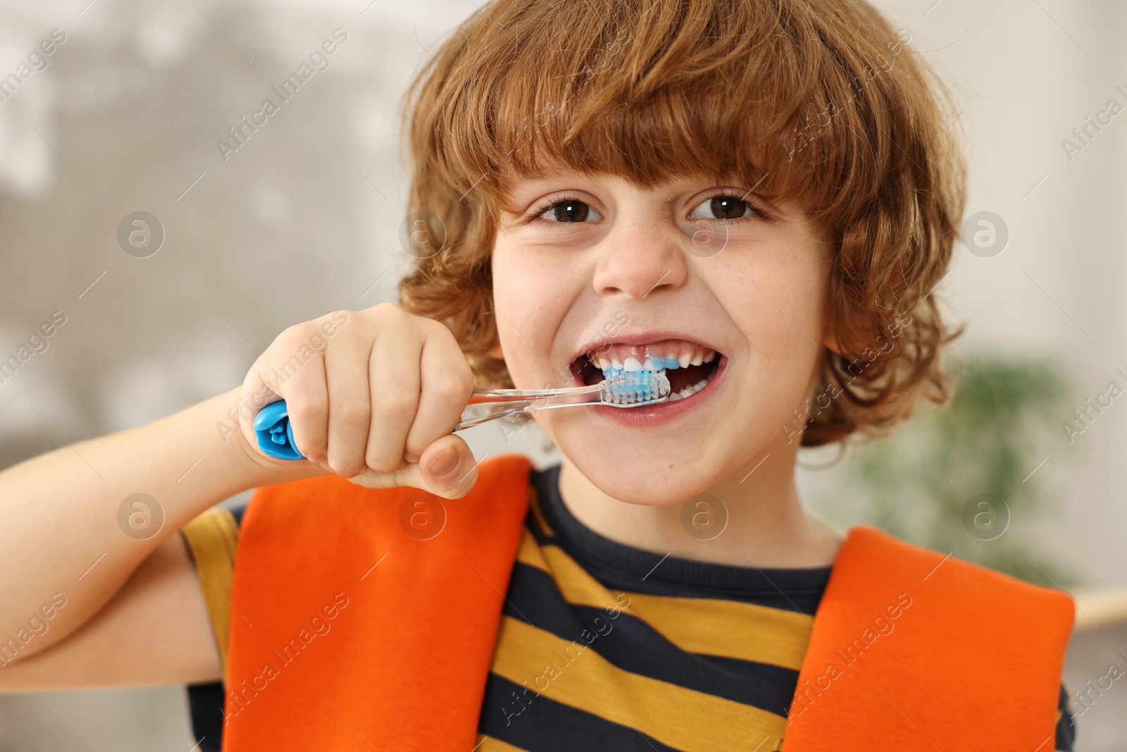 Photo of Cute boy brushing his teeth at home