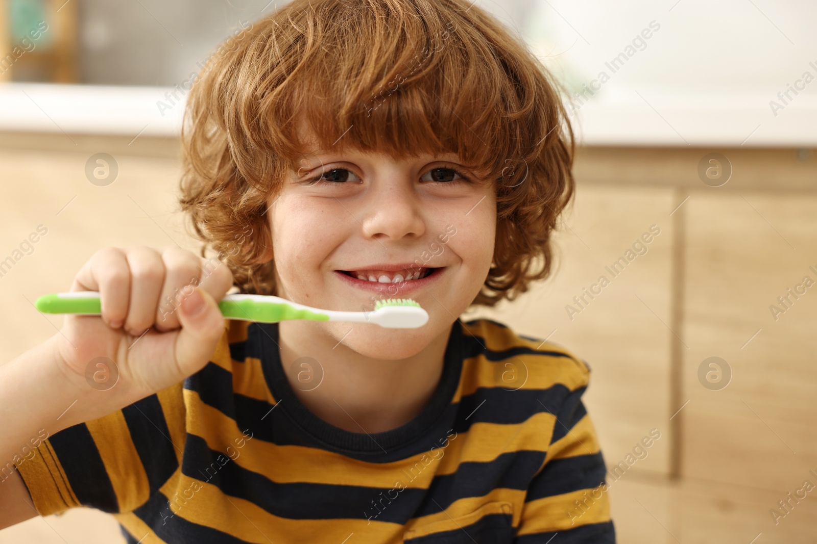 Photo of Cute boy brushing his teeth at home