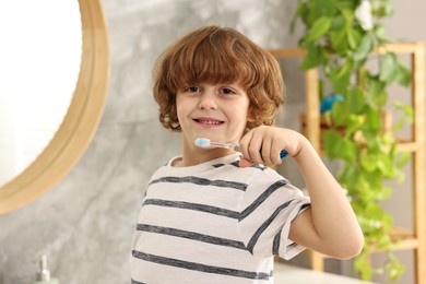 Cute boy brushing his teeth in bathroom