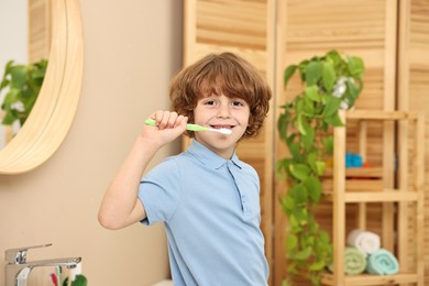 Cute boy brushing his teeth in bathroom