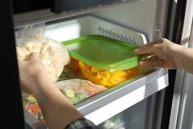 Photo of Woman taking frozen vegetables from refrigerator, closeup