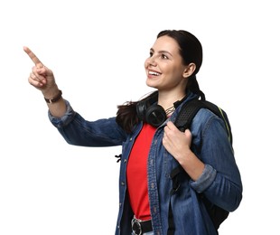 Photo of Young tourist with backpack and headphones pointing at something on white background