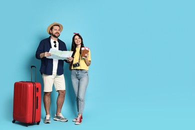 Photo of Tourism. Happy couple with map and suitcase on light blue background, space for text