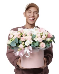 Photo of Smiling delivery man holding gift box with beautiful floral composition on white background