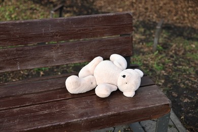 Photo of Lost white teddy bear on wooden bench in park