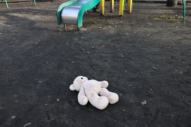 Photo of Lost white teddy bear on ground outdoors