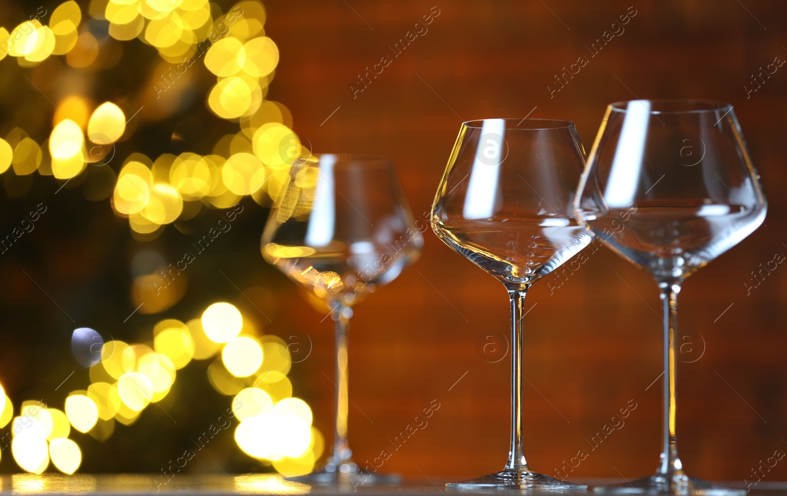 Photo of Wine glasses on table against blurred lights. Bokeh effect