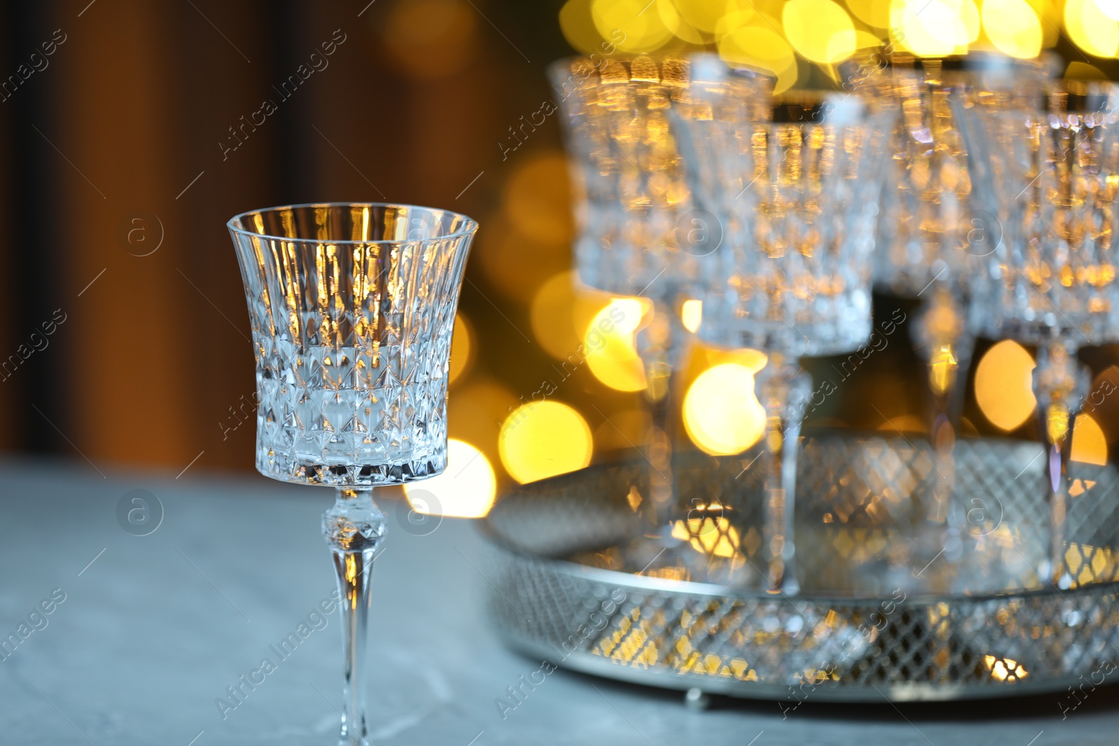 Photo of Wine in glasses on table against blurred lights. Bokeh effect