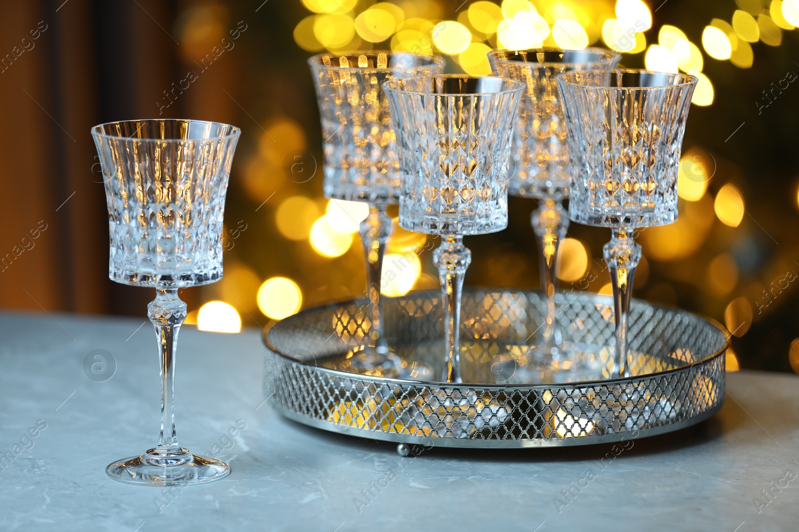 Photo of Wine in glasses on table against blurred lights. Bokeh effect