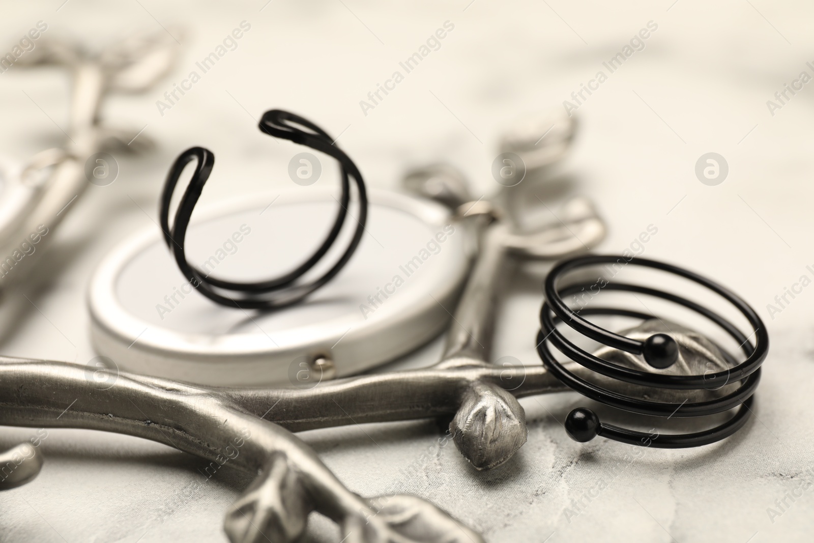 Photo of Stylish presentation of rings on white marble table, closeup