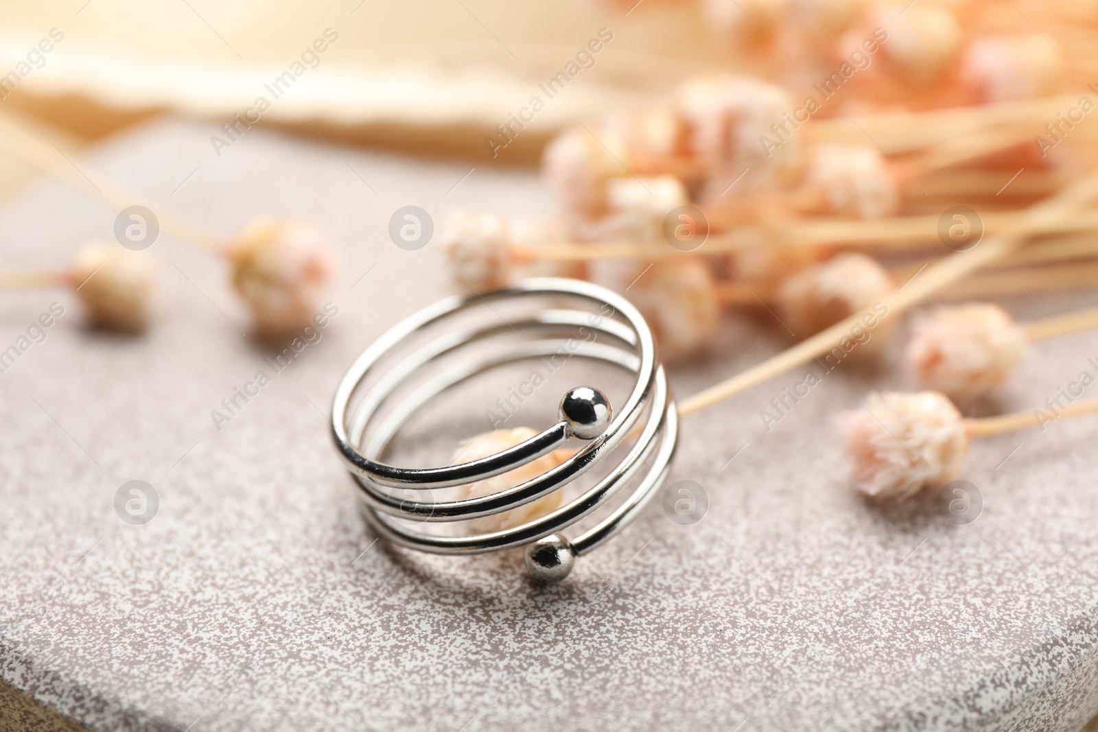 Photo of One stylish ring on stone surface, closeup