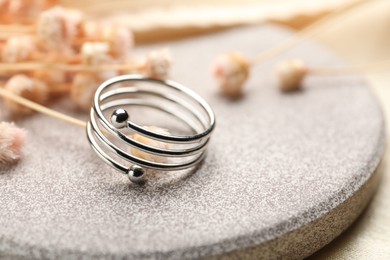 Photo of One stylish ring on stone surface, closeup. Space for text