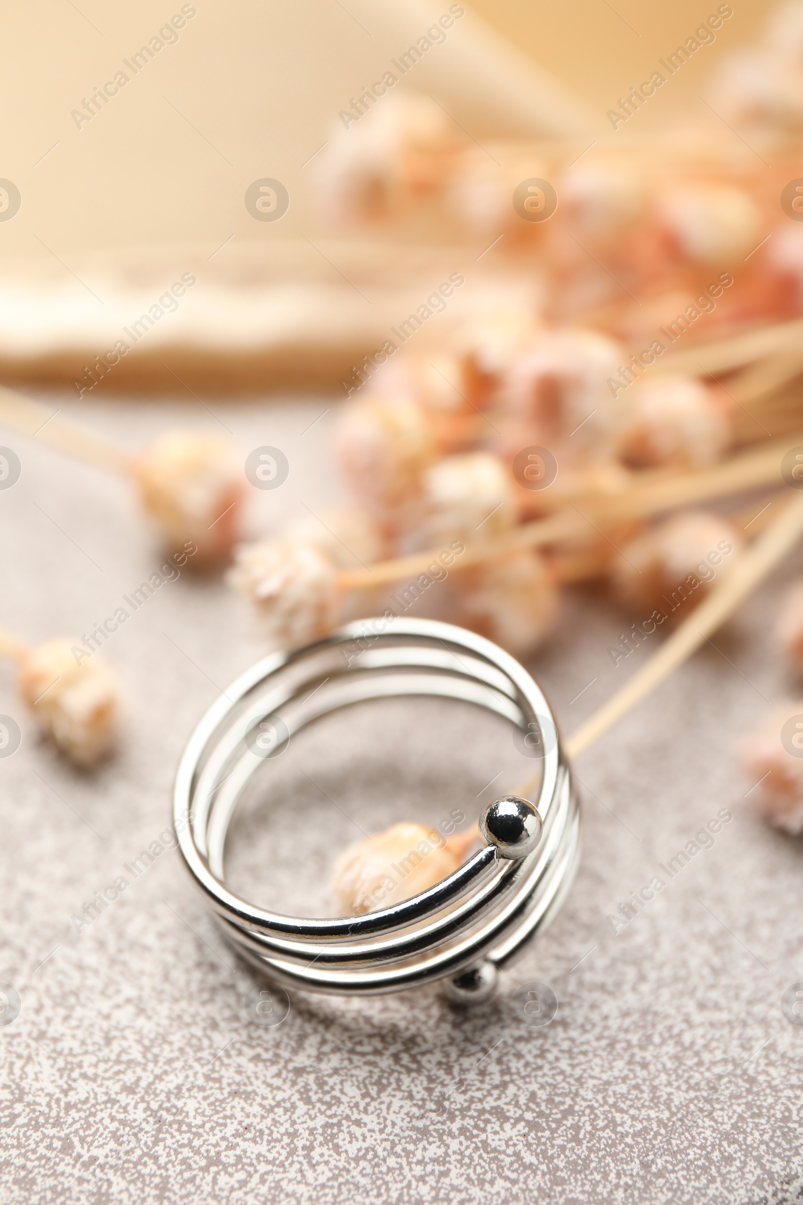 Photo of One stylish ring on stone surface, closeup