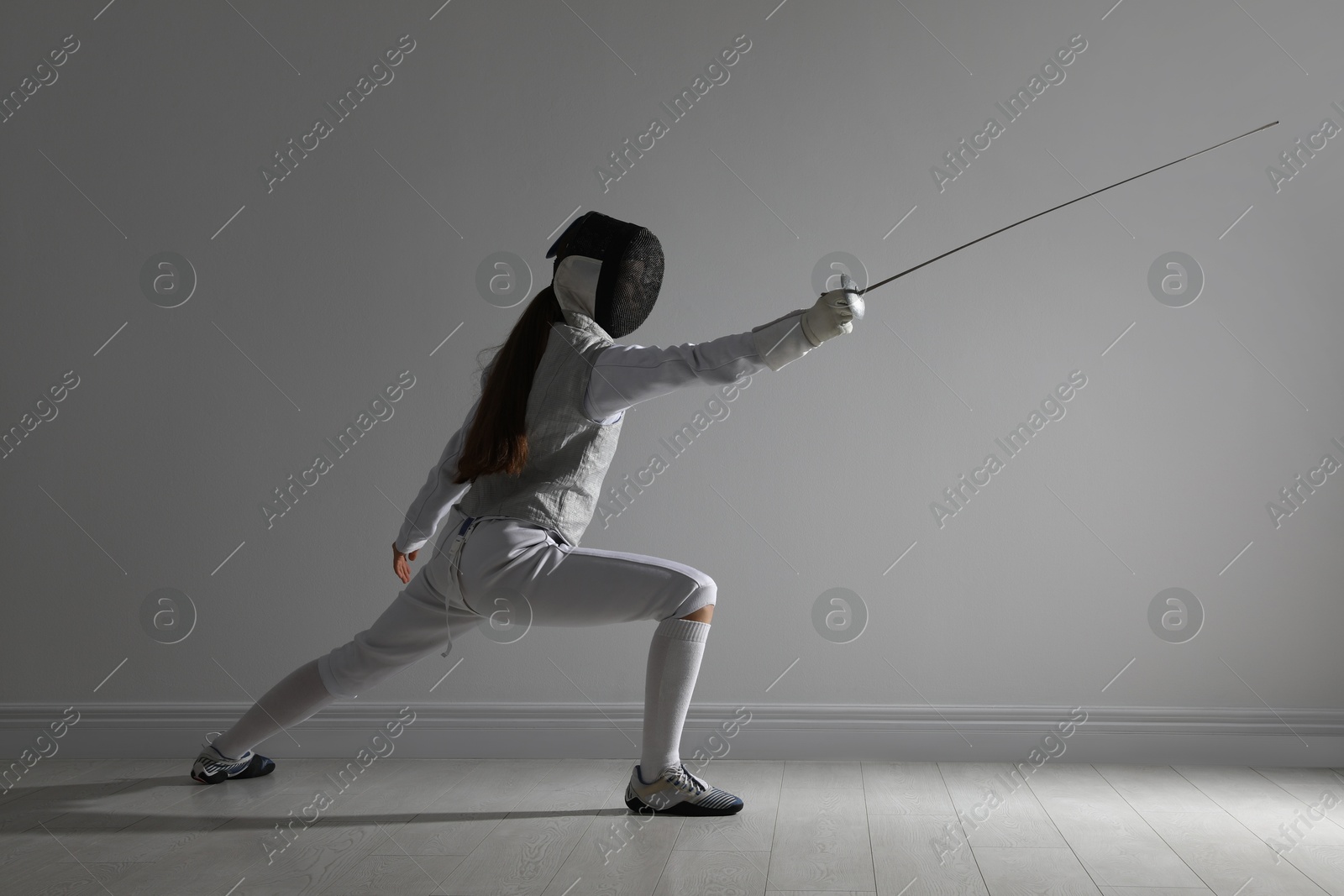 Photo of Fencer with epee practicing indoors. Combat sport