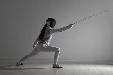 Photo of Fencer with epee practicing indoors. Combat sport