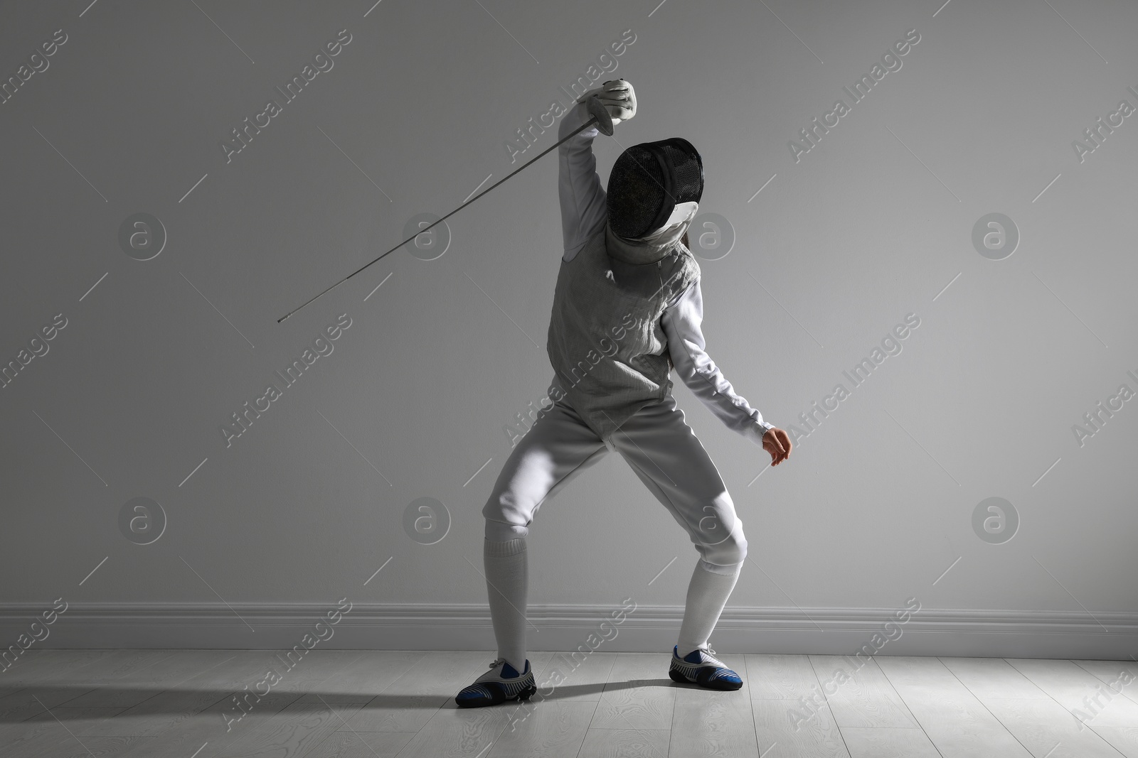 Photo of Fencer with epee practicing indoors. Combat sport