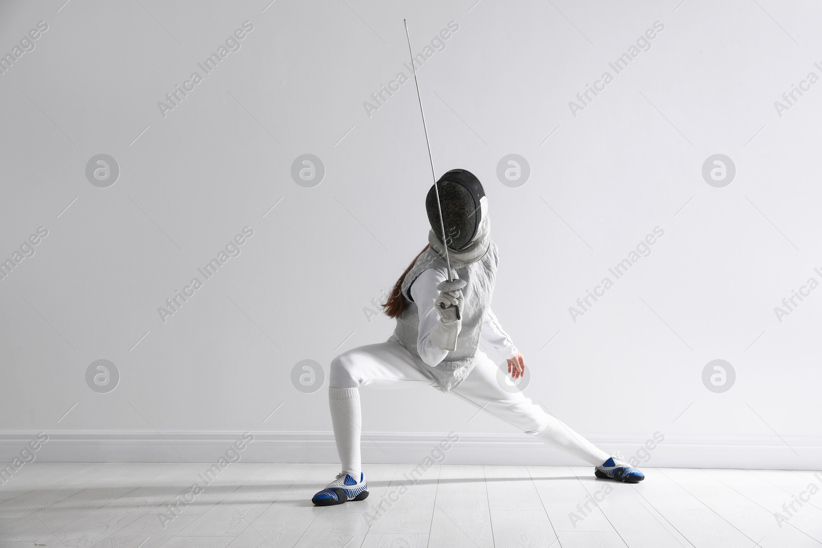 Photo of Fencer with epee practicing indoors. Combat sport