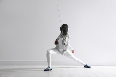 Photo of Fencer with epee practicing indoors. Combat sport