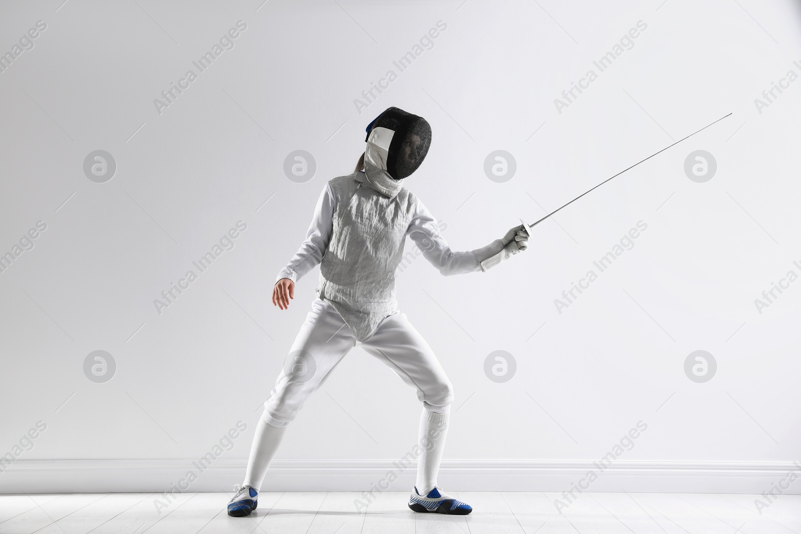 Photo of Fencer with epee practicing indoors. Combat sport