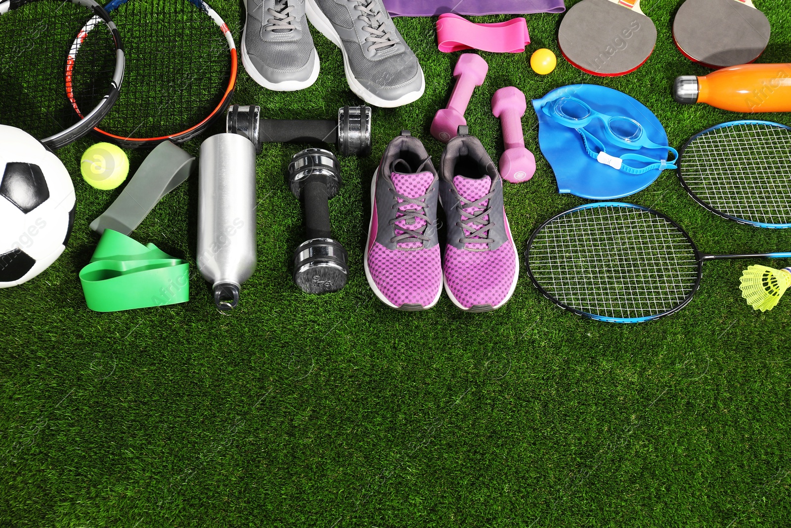 Photo of Different sport equipment on artificial grass, flat lay. Space for text