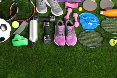 Photo of Different sport equipment on artificial grass, flat lay. Space for text