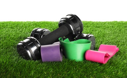 Photo of Different sport equipment on artificial grass isolated on white