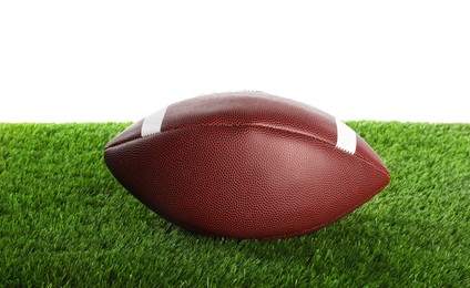 Photo of American football ball on artificial grass isolated on white. Sport equipment