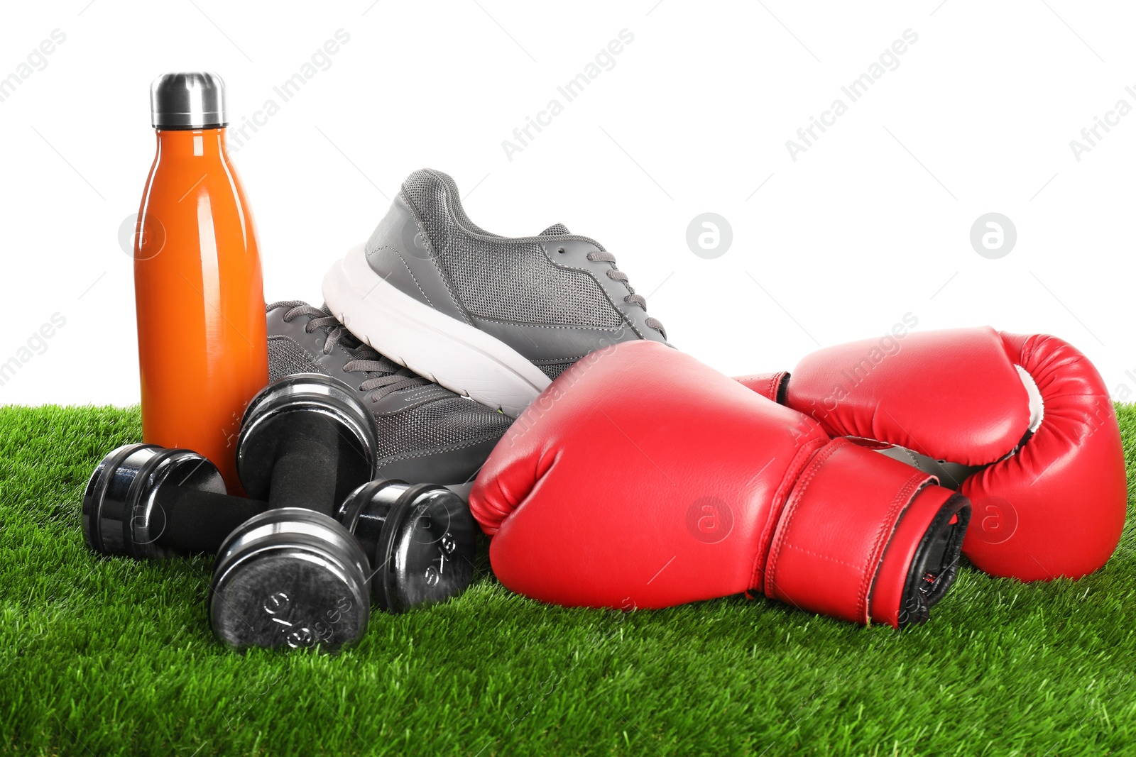 Photo of Different sport equipment on artificial grass isolated on white