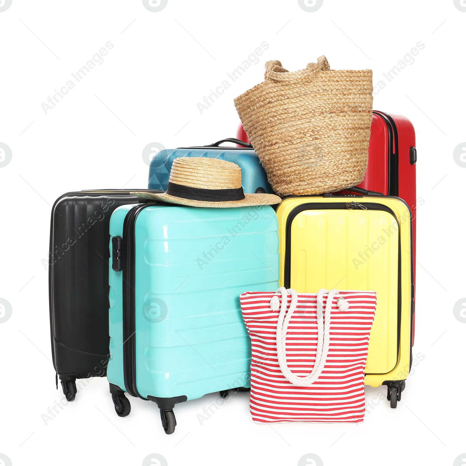 Photo of Many colorful suitcases, beach bags and straw hat isolated on white