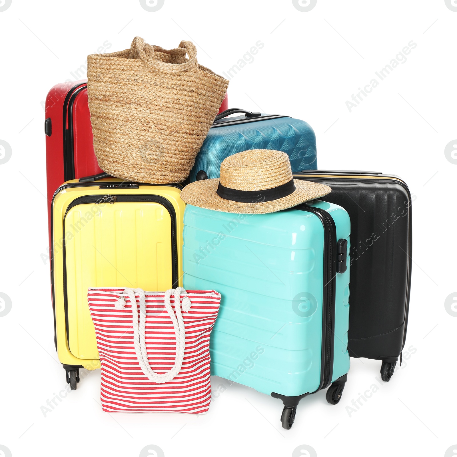 Photo of Many colorful suitcases, beach bags and straw hat isolated on white