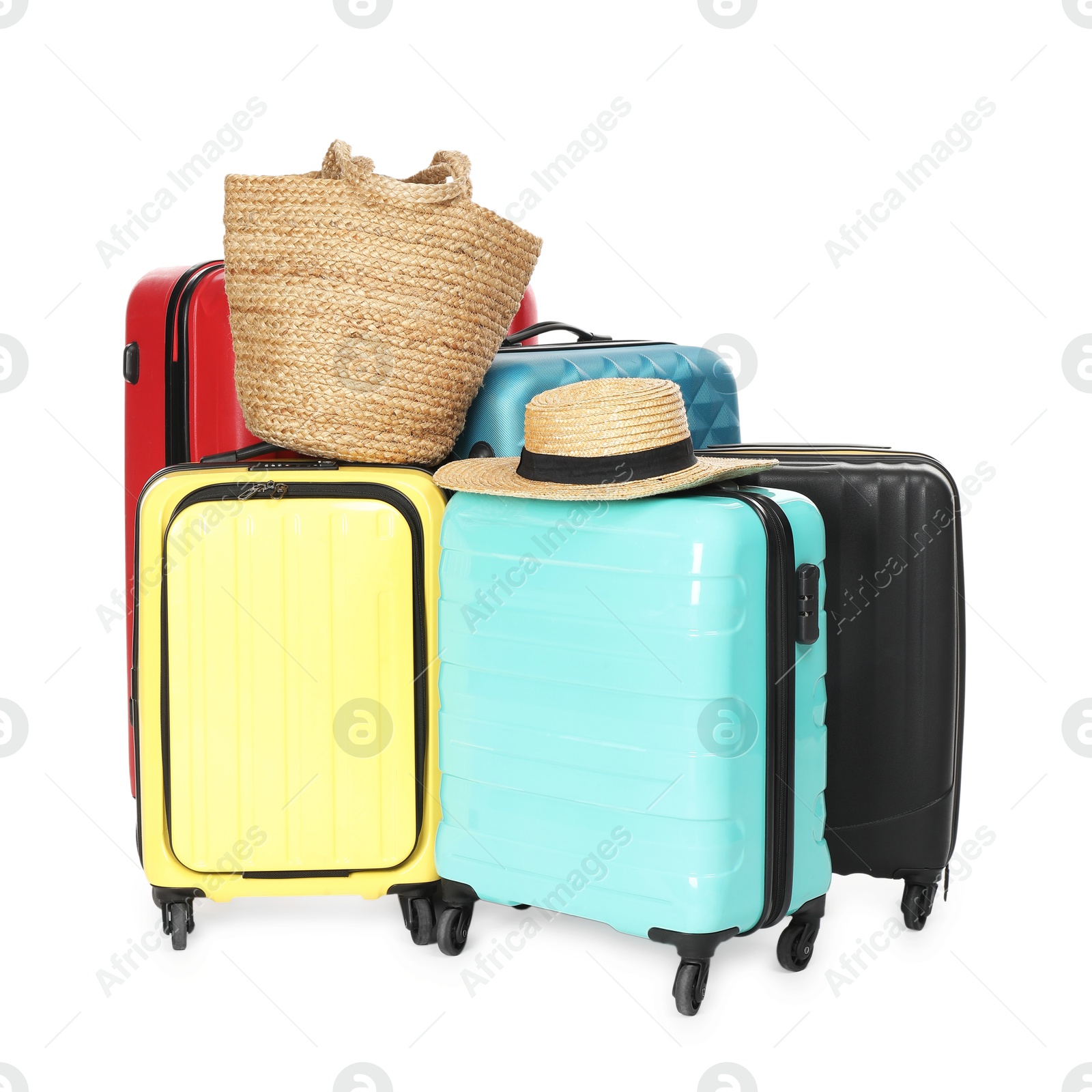 Photo of Many colorful suitcases, beach bag and straw hat isolated on white