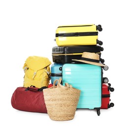 Photo of Stack of colorful suitcases, backpack, beach bag and straw hat isolated on white