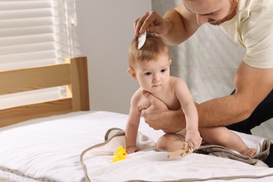 Photo of Man combing hair of his little baby indoors, space for text