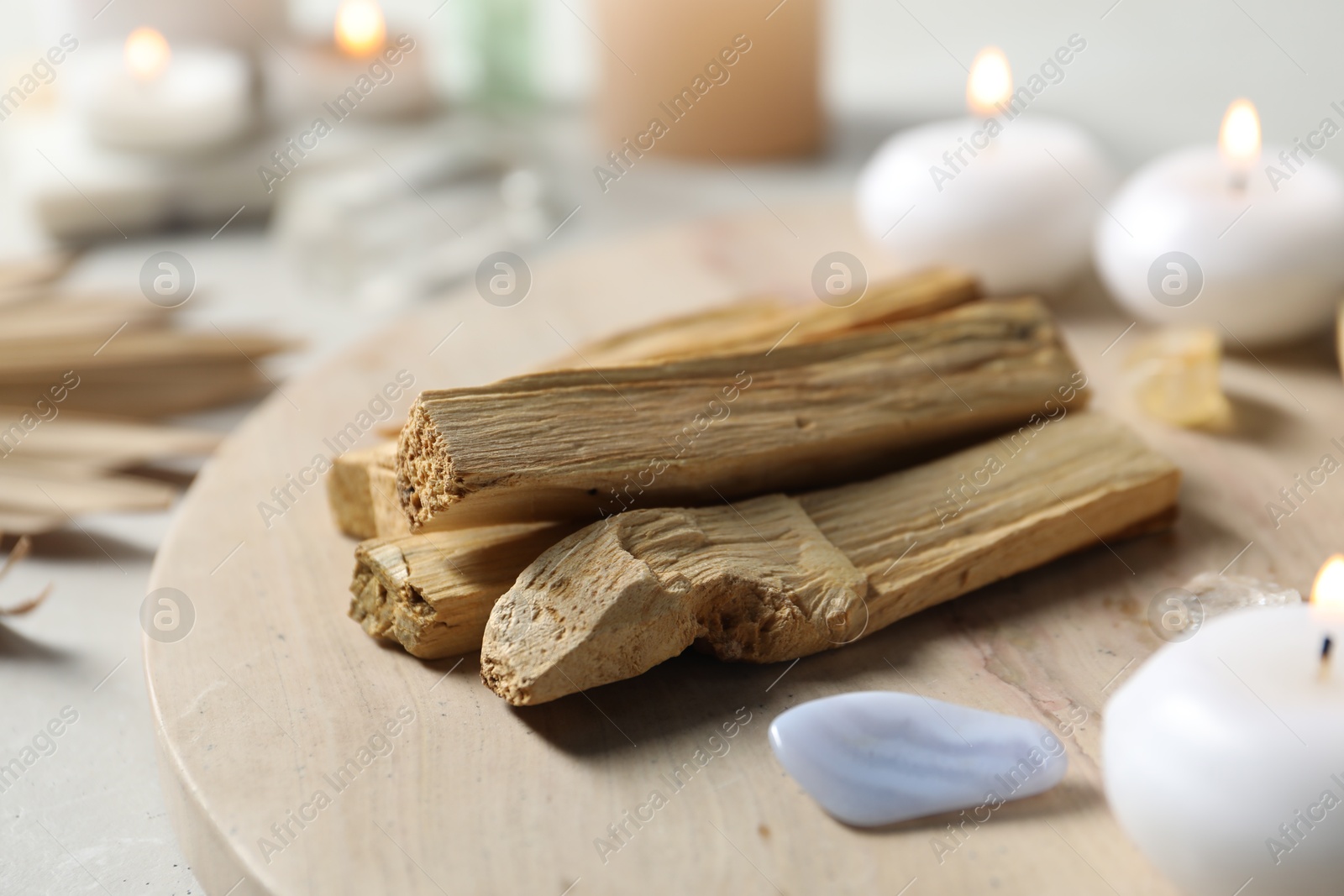 Photo of Palo santo sticks and gemstone on light table, closeup