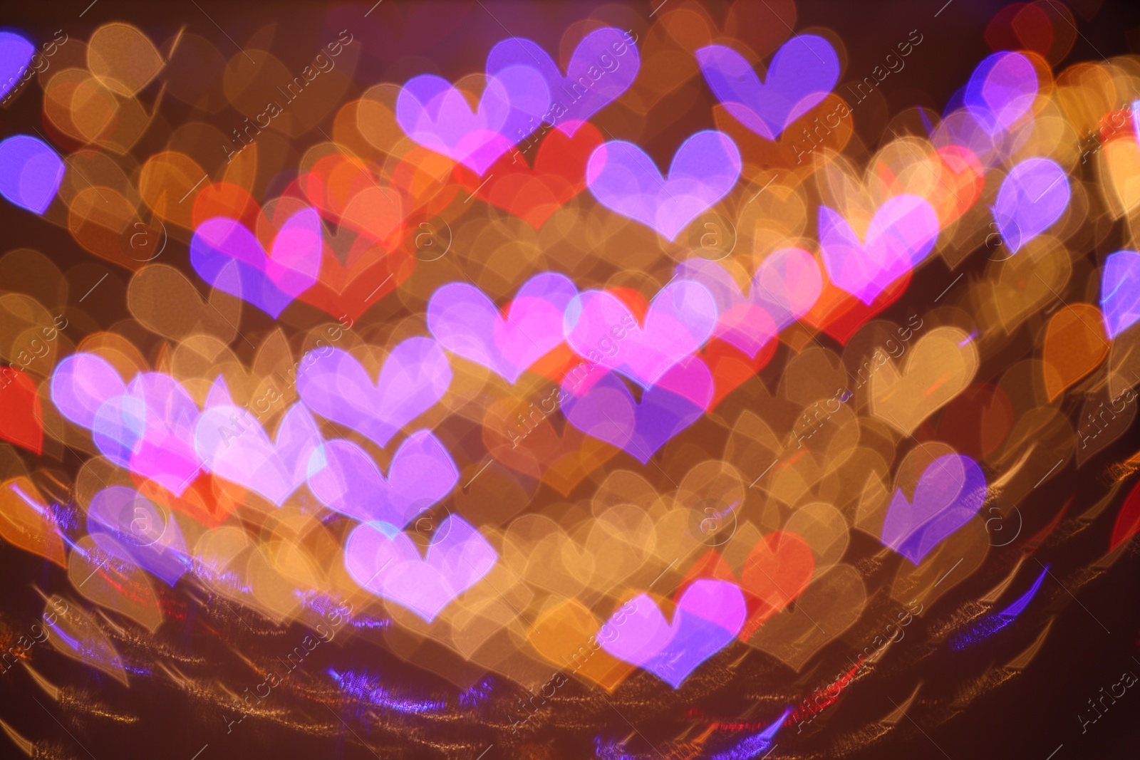 Photo of Romantic decor. Blurred view of heart shaped lights on color background, bokeh effect