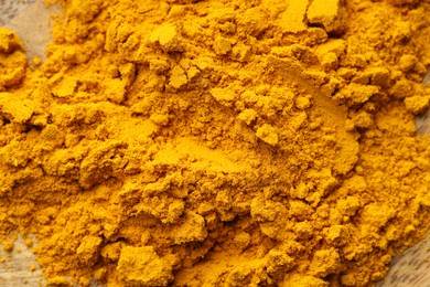 Photo of Heap of turmeric powder on table, top view