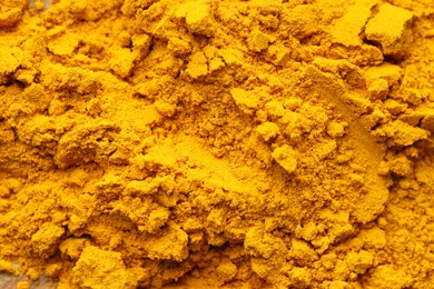 Photo of Heap of turmeric powder on table, top view