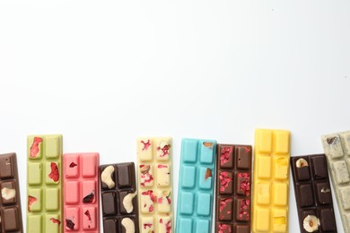 Photo of Different tasty chocolate bars on white background, flat lay. Space for text