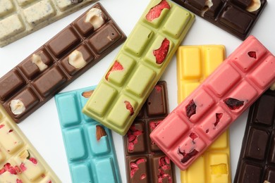 Photo of Different tasty chocolate bars on white background, flat lay