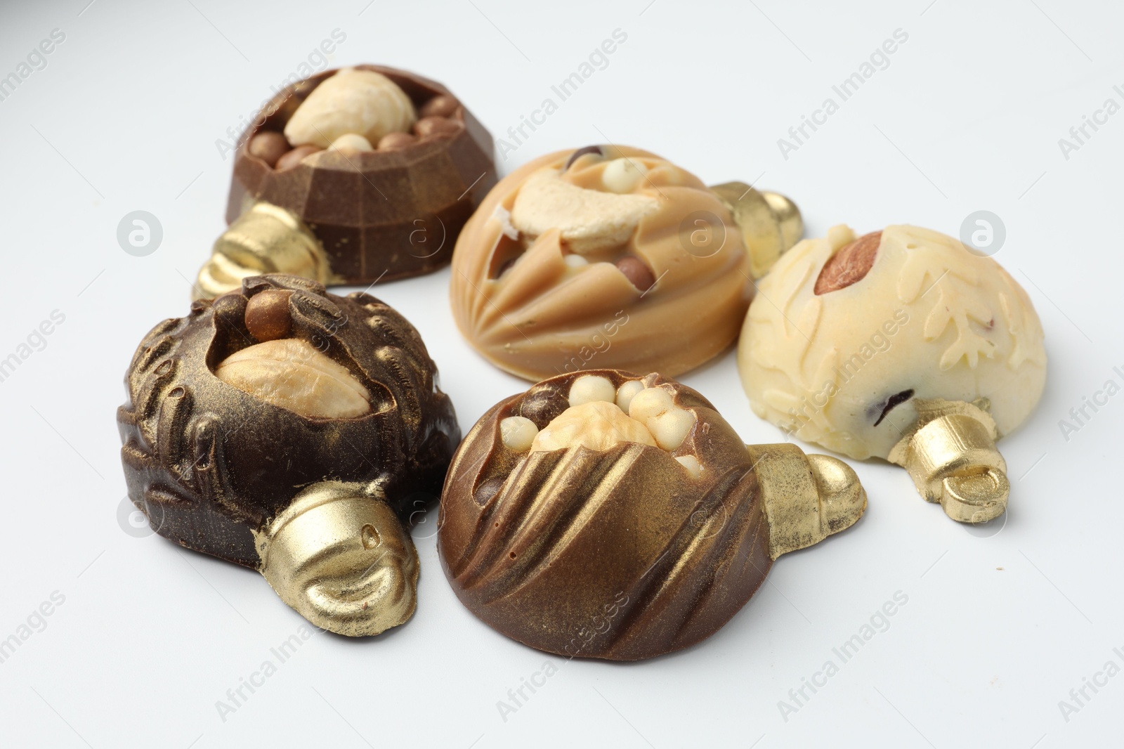 Photo of Delicious chocolate in shape of Christmas baubles on white background, closeup